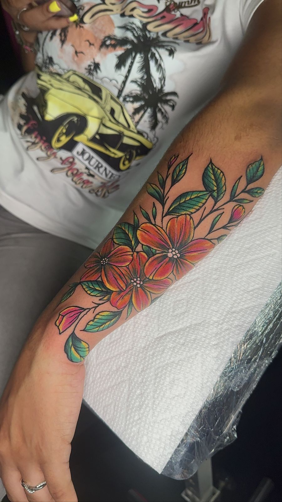 Orange and red floral forearm tattoo